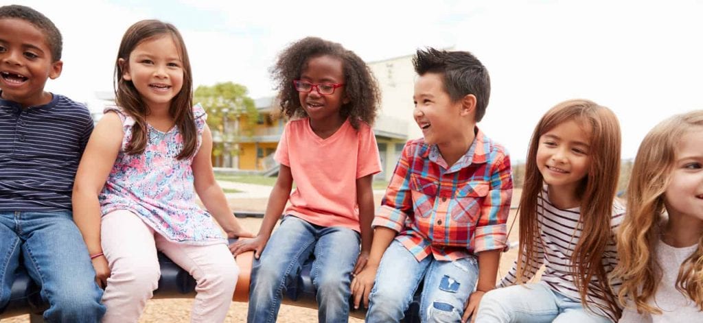 A group of children play on playground equipment.