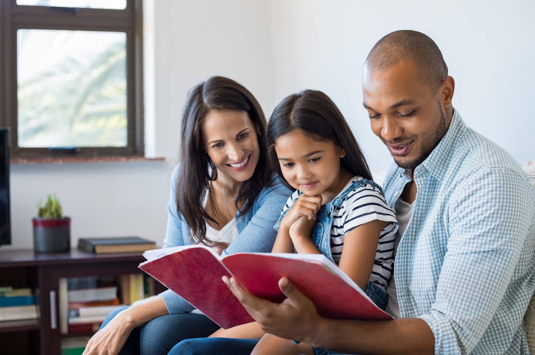 parents looking at book with child