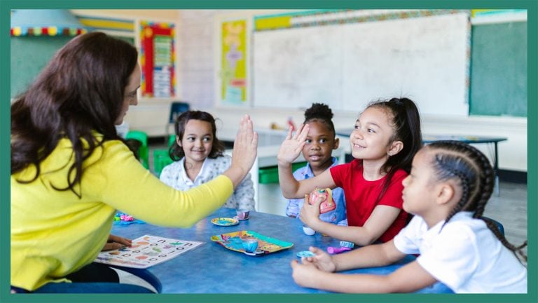 child giving a high five to the teacher in a classroom