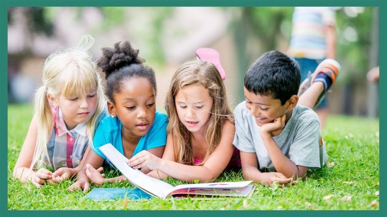 children reading on grass, outside