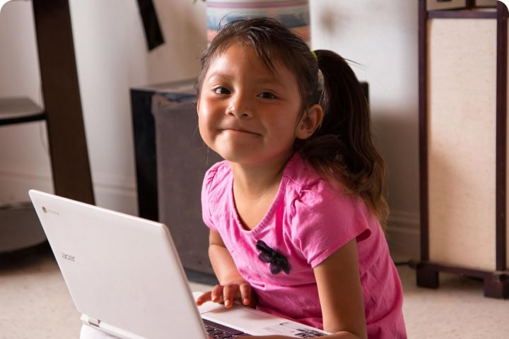 girl smiling in front of a laptop