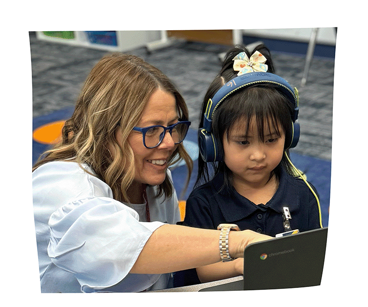 Teacher explaining something to a student in front of a laptop